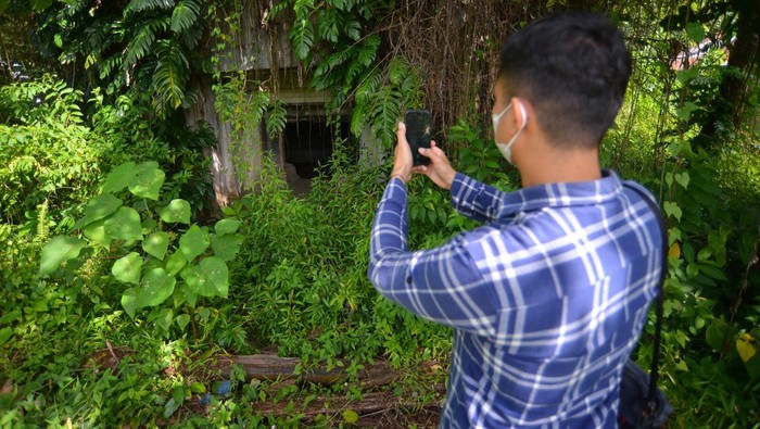 Jejak Sejarah Benteng Pertahanan Peninggalan Jepang di Padang yang Kini Terbengkalai Warga memotret pintu masuk benteng pertahanan Jepang yang terbengkelai di Ulak Karang, Padang, Sumatera Barat, Jumat (13/1/2023). Benteng pertahanan Jepang yang memiliki dua kamar dan satu ruangan pengintaian dengan panjang total 22 meter itu berpotensi dikembangkan menjadi objek wisata sejarah karena berada di dekat pantai.