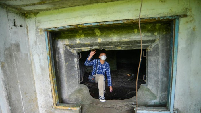 Jejak Sejarah Benteng Pertahanan Peninggalan Jepang di Padang yang Kini Terbengkalai Warga memotret pintu masuk benteng pertahanan Jepang yang terbengkelai di Ulak Karang, Padang, Sumatera Barat, Jumat (13/1/2023). Benteng pertahanan Jepang yang memiliki dua kamar dan satu ruangan pengintaian dengan panjang total 22 meter itu berpotensi dikembangkan menjadi objek wisata sejarah karena berada di dekat pantai.