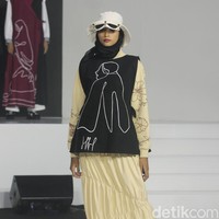 Koleksi busana Hannie Hananto dengan gambar perempuan yang artsy. Hannie merilis busana muslim yang didominasi warna marun, krem dan hitam di Jakarta Fashion Trend 2023.  Foto: Mohammad Abduh/Wolipop.