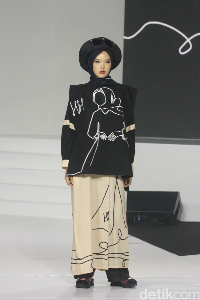 Koleksi busana Hannie Hananto dengan gambar perempuan yang artsy. Hannie merilis busana muslim yang didominasi warna marun, krem dan hitam di Jakarta Fashion Trend 2023.  Foto: Mohammad Abduh/Wolipop.
