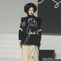 Koleksi busana Hannie Hananto dengan gambar perempuan yang artsy. Hannie merilis busana muslim yang didominasi warna marun, krem dan hitam di Jakarta Fashion Trend 2023.  Foto: Mohammad Abduh/Wolipop.