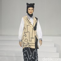 Koleksi busana Hannie Hananto dengan gambar perempuan yang artsy. Hannie merilis busana muslim yang didominasi warna marun, krem dan hitam di Jakarta Fashion Trend 2023. . Foto: Mohammad Abduh/Wolipop.