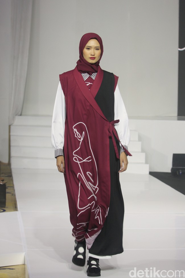 Koleksi busana Hannie Hananto dengan gambar perempuan yang artsy. Hannie merilis busana muslim yang didominasi warna marun, krem dan hitam di Jakarta Fashion Trend 2023. Foto: Mohammad Abduh/Wolipop.
