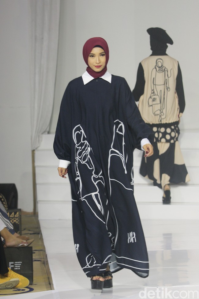 Koleksi busana Hannie Hananto dengan gambar perempuan yang artsy. Hannie merilis busana muslim yang didominasi warna marun, krem dan hitam di Jakarta Fashion Trend 2023. Foto: Mohammad Abduh/Wolipop.