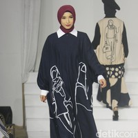 Koleksi busana Hannie Hananto dengan gambar perempuan yang artsy. Hannie merilis busana muslim yang didominasi warna marun, krem dan hitam di Jakarta Fashion Trend 2023. Foto: Mohammad Abduh/Wolipop.