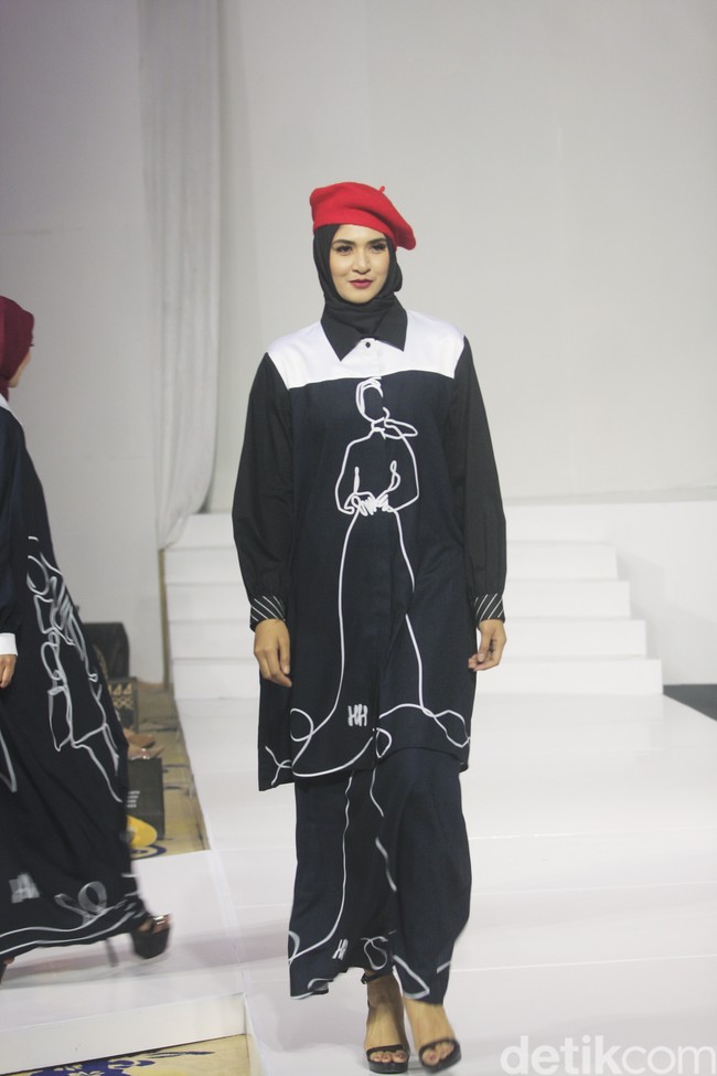 Koleksi busana Hannie Hananto dengan gambar perempuan yang artsy. Hannie merilis busana muslim yang didominasi warna marun, krem dan hitam di Jakarta Fashion Trend 2023.  Foto: Mohammad Abduh/Wolipop.