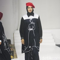 Koleksi busana Hannie Hananto dengan gambar perempuan yang artsy. Hannie merilis busana muslim yang didominasi warna marun, krem dan hitam di Jakarta Fashion Trend 2023.  Foto: Mohammad Abduh/Wolipop.