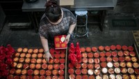 Pemilik usaha merapikan kue keranjang sebelum dikirim di rumah produksi kue keranjang Mini Bakery, Sangkrah, Solo, Jawa Tengah, Kamis (12/1/2023). ANTARA FOTO/Mohammad Ayudha.