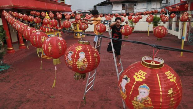 Dua orang pekerja memasang  lampion di Klenteng Thian Hou Kiong Kelurahan Gamalama, Kota Ternate, Maluku Utara, Jumat (13/1/2023).Pemasangan lampion tersebut dan sejumlah persiapan dalam rangka menyambut tahun baru imlek 2574 yang jatuh pada Minggu (22/1/2023) mendatang. ANTARA FOTO/Andri Saputra/foc.