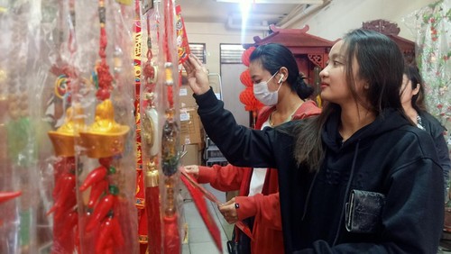 Pengunjung Mutiara Bali saat melihat-lihat di Jalan Dr. Sutomo 14 A Denpasar, Bali, tampak tengah memilih pernak-pernik Imlek, Jumat (13/1/2023).