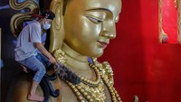 Seorang pria membersihkan rupang Buddha di Vihara Satya Buddha di Medan, Minggu (12/1/2023).