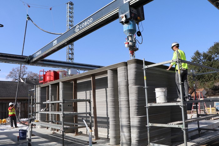 A construction worker watches as a 3-D printer lays concrete for the first 3-D-printed, two-story home in the U.S. under construction in Houston, Texas, U.S., January 3, 2023. REUTERS/Evan Garcia