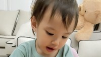 Claire rupanya juga suka makan pizza. Ia mengambil sepotong pizza dan sesekali mencocolnya ke saus sebelum dimasukkan ke mulut. Wah, pintar!