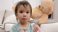 Layaknya orang dewasa, Claire hobi nyantai sambil ngemil chips. Duduknya saja santai banget ya?
