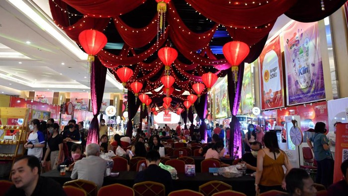 Kepo Market Surabaya Hadir Sambut Tahun Baru Imlek AVP SME Acquisition DOKU Herunata Joseph (kedua kanan) dan Founder Kepo Market Michael Putra Bani (kanan) berbincang dengan pengunjung yang sedang melakukan transaksi dengan menggunakan aplikasi dompet elektronik saat bazar kuliner Kepo Market di Surabaya, Jawa Timur, Sabtu (14/1/2023). Kepo Market yang disajikan dalam nuansa menyambut tahun baru Imlek tersebut menjadi wadah bagi pemilik bisnis UMKM untuk memasarkan produk mereka lebih luas ke konsumen dan DOKU menjadi opsi pembayaran non tunai melalui pindai QRIS. ANTARA FOTO/Zabur Karuru/foc.