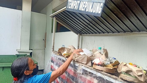 Nyoman Sari (50) saat  menghaturkan sarana dalam tradisi mepunjung di Kamar Jenazah RSUP Prof Ngoerah, Jalan Diponegoro, Denpasar, Bali, Jumat (13/1/2023).