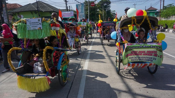 PARADE GUNUNGAN DAN KARNAVAL BECAK HIAS Sejumlah warga mengikuti kirab saat Parade Gunungan Terbesar dan Karnaval Becak Hias di Pekalongan, Jawa Tengah, Sabtu (14/1/2023). Kegiatan yang diselenggarakan oleh Kementerian Agama tersebut dalam rangka memperingati Hari Amal Bhakti yang ke-77 dengan tema 'Kerukunan Umat Untuk Indonesia Hebat', guna tercipta kerukunan antar umat beragama dalam kehidupan bermasyarakat. ANTARA FOTO/Harviyan Perdana Putra/YU
