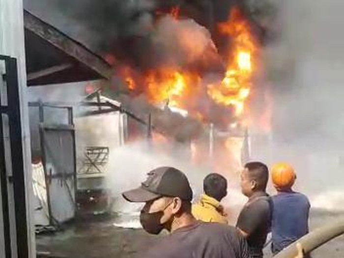 Petugas dan warga memadamkan api di gudang yang terbakar di Lubuklinggau. (screenshot video)