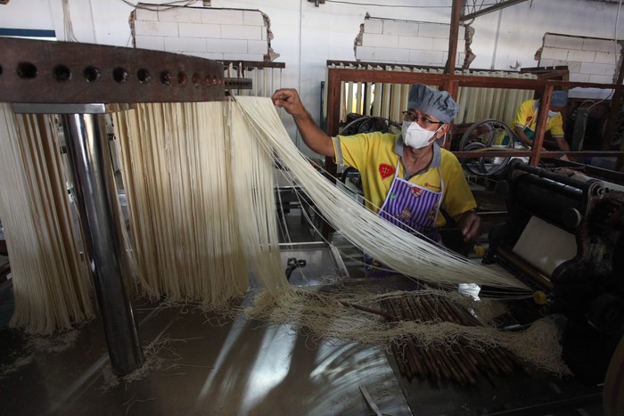Pekerja menata misua untuk dikeringkan di salah satu industri rumahan di kawasan Pesapen, Surabaya, Jawa Timur, Sabtu (14/1/2023). Produksi mi tradisional China tersebut mengalami peningkatan hingga 100 persen yang biasanya menghabiskan 500 kilogram tepung menjadi satu ton tepung akibat meningkatnya permintaan menjelang tahun baru Imlek. ANTARA FOTO/Didik Suhartono/YU