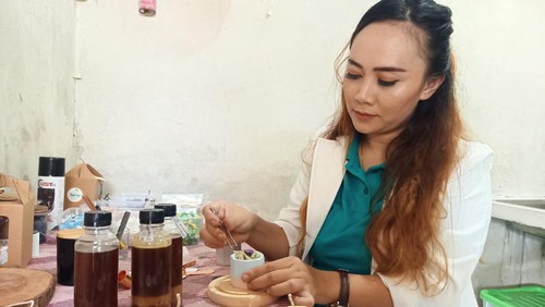 Salah satu owner Sinar Bumi Menghijau, Yunia Nurbaiti (30) saat  menunjukkan proses pembuatan lilin aromaterapi berbahan dasar minyak jelantah, Jumat (13/1/2023).