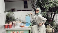 Salah satunya ini saat Olla Ramlan mencoba berjualan pentol gerobakan. Warna bajunya serasi dengan gerobak pentol itu ya? Foto: Instagram @ollaramlan