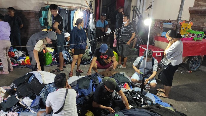 Lokasi pedagang pakaian bekas di Pasar Badung berada di sebelah timur gedung utama pasar. detikBali ke lokasi sekitar pukul 19.37 Wita dan lokasi sudah dipadati oleh warga yang mencari pakaian bekas. (I Wayan Sui Suadnyana/detikBali)