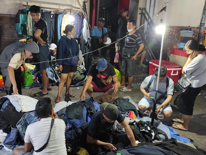 Lokasi pedagang pakaian bekas di Pasar Badung berada di sebelah timur gedung utama pasar. detikBali ke lokasi sekitar pukul 19.37 Wita dan lokasi sudah dipadati oleh warga yang mencari pakaian bekas. (I Wayan Sui Suadnyana/detikBali)