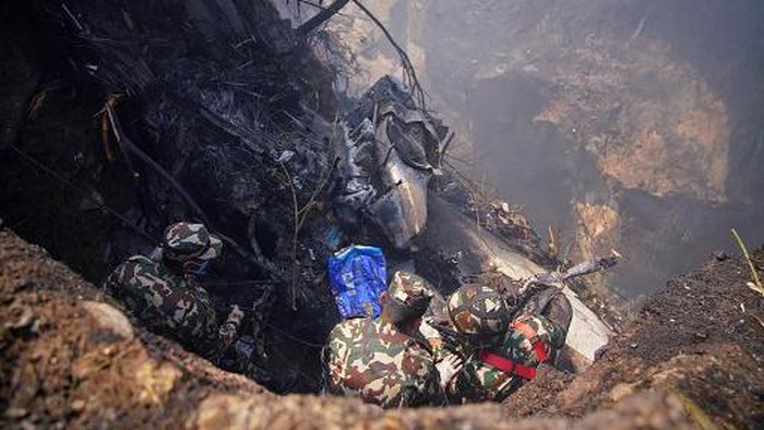 Rescuers inspect the site of a plane crash in Pokhara on January 15, 2023. - An aircraft with 72 people on board crashed in Nepal on January 15, Yeti Airlines and a local official said. (Photo by Yunish Gurung / AFP)