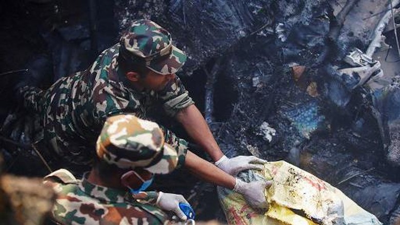 NEPAL-ACCIDENT-AIR Rescuers inspect the site of a plane crash in Pokhara on January 15, 2023. - An aircraft with 72 people on board crashed in Nepal on January 15, Yeti Airlines and a local official said. (Photo by Yunish Gurung / AFP)