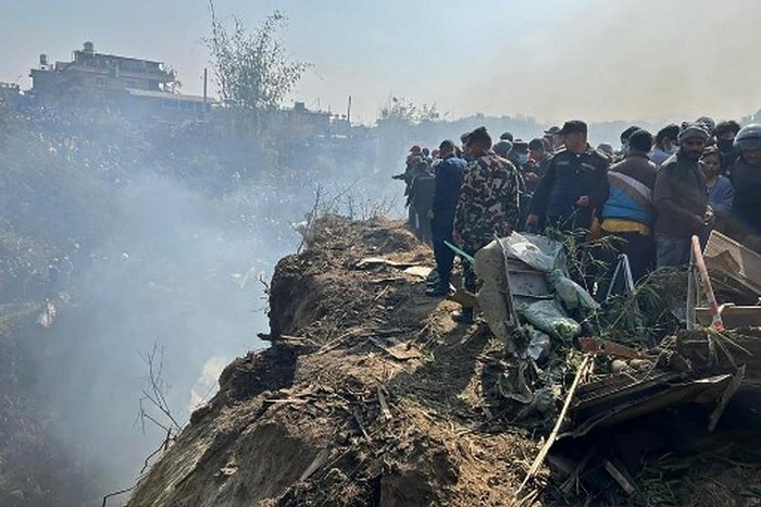 Rescuers inspect the site of a plane crash in Pokhara on January 15, 2023. - An aircraft with 72 people on board crashed in Nepal on January 15, Yeti Airlines and a local official said. (Photo by Yunish Gurung / AFP)