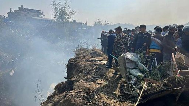 NEPAL-ACCIDENT-AIR Rescuers inspect the site of a plane crash in Pokhara on January 15, 2023. - An aircraft with 72 people on board crashed in Nepal on January 15, Yeti Airlines and a local official said. (Photo by Yunish Gurung / AFP)