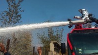 Setelah kecelakaan itu, petugas penyelamat menyemprot bagian pesawat ATR 72 bermesin ganda turboprop yang terbakar itu. Sementara asap mengepul dari jurang saat ratusan orang menyaksikan. Bishan Chetri/Getty Images