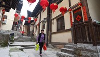 Seorang warga berjalan di sepanjang di Jalan Kuno Huangge yang berhiaskan pernak-pernik imlek.