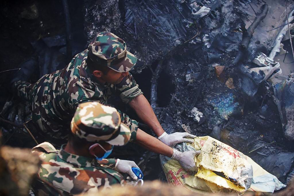 Sebuah pesawat berpenumpang 72 orang milik Yeti Airlines jatuh di Nepal pada Minggu (15/1). Puing pesawat terbakar dan petugas sedang melakukan penyelamatan. (AFP via Getty Images/YUNISH GURUNG)