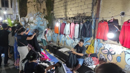 Thrifting atau kegiatan yang mencari atau berbelanja barang bekas layak pakai kini semakin digemari oleh masyarakat. Hal itu pula yang terlihat di Pasar Badung, Kota Denpasar, Bali, Minggu, (15/1/2023) malam. Warga nampak berjubel memenuhi pedagang pakaian bekas. (I Wayan Sui Suadnyana)