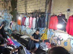 Thrifting atau kegiatan yang mencari atau berbelanja barang bekas layak pakai kini semakin digemari oleh masyarakat. Hal itu pula yang terlihat di Pasar Badung, Kota Denpasar, Bali, Minggu, (15/1/2023) malam. Warga nampak berjubel memenuhi pedagang pakaian bekas. (I Wayan Sui Suadnyana)