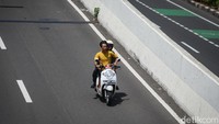 Ada pula warga yang melintas JLNT dan tidak memakai helm. 