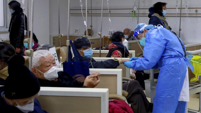 In this photo released by Xinhua News Agency, A medical worker helps a patient on the intravenous drip at a community healthcare institution in Shanghai, China, Monday, Jan. 5, 2023. As COVID-19 rips through China, other countries and the WHO are calling on its government to share more comprehensive data on the outbreak, with some even saying many of the numbers it is reporting are meaningless. (Fang Zhe/Xinhua via AP)