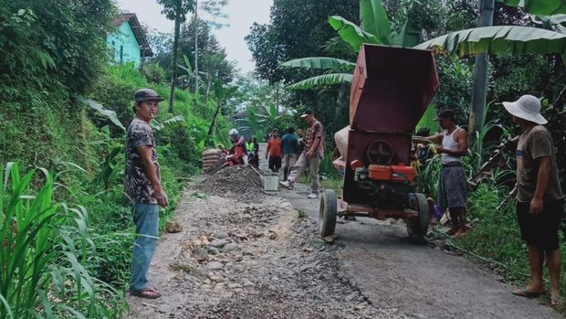 Warga di Desa Domyang, Pekalongan, bekerja bakti memperbaiki jalan kabupaten yang rusak.