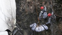 Tim penyelamat berusaha menarik jenazah korban dari jurang. Pesawat Yeti Airines yang jatuh itu terbelah dua, satu bagian berada di lereng bukit, sementara bagian lain jatuh ke ngarai sungai.