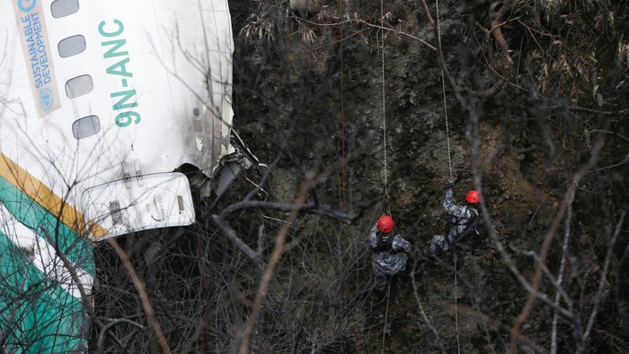 Aksi Dramatis Tim Penyelamat Evakuasi Korban Pesawat Jatuh di Nepal A rescue team works to recover the body of a victim from the site of the plane crash of a Yeti Airlines operated aircraft, in Pokhara, Nepal January 16, 2023. REUTERS/Rohit Giri NO RESALES. NO ARCHIVES