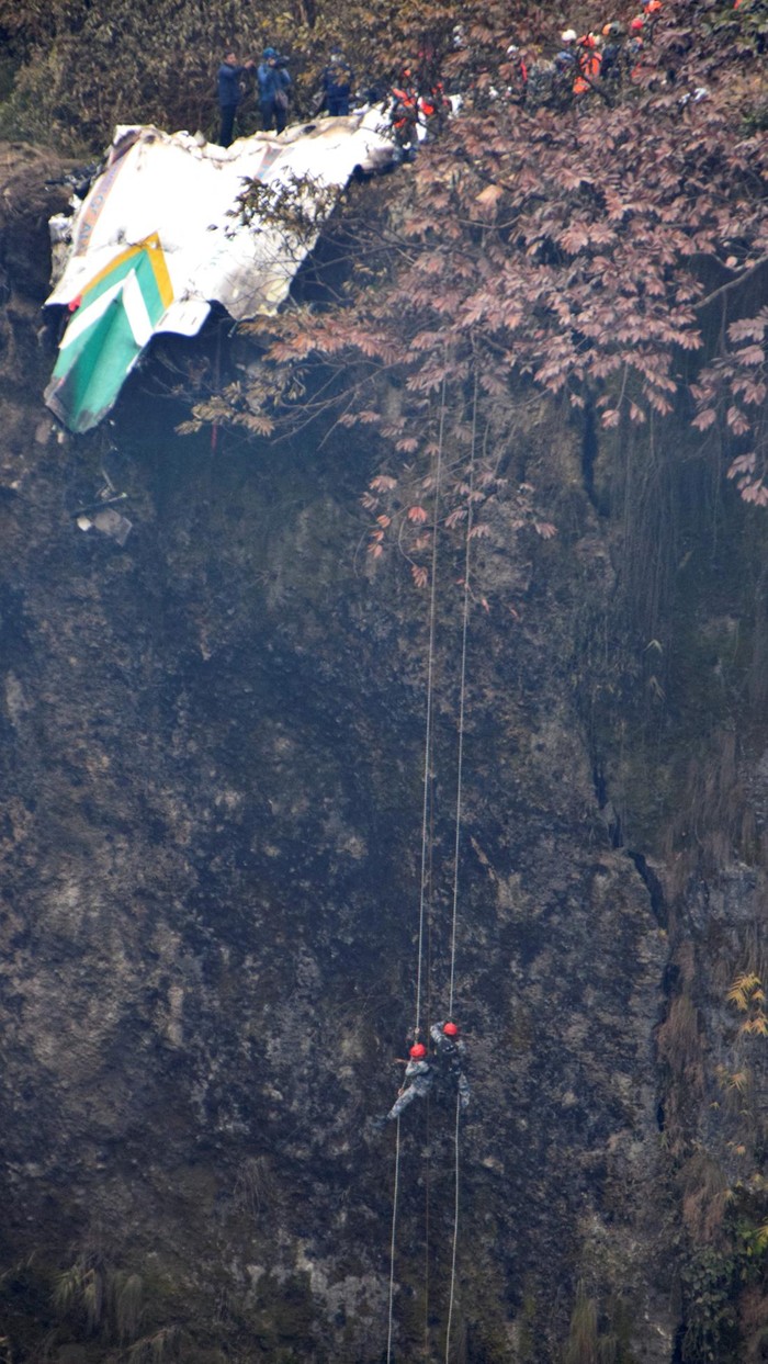 Aksi Dramatis Tim Penyelamat Evakuasi Korban Pesawat Jatuh di Nepal A rescue team works to recover the body of a victim from the site of the plane crash of a Yeti Airlines operated aircraft, in Pokhara, Nepal January 16, 2023. REUTERS/Krishna Mani Baral NO RESALES. NO ARCHIVES