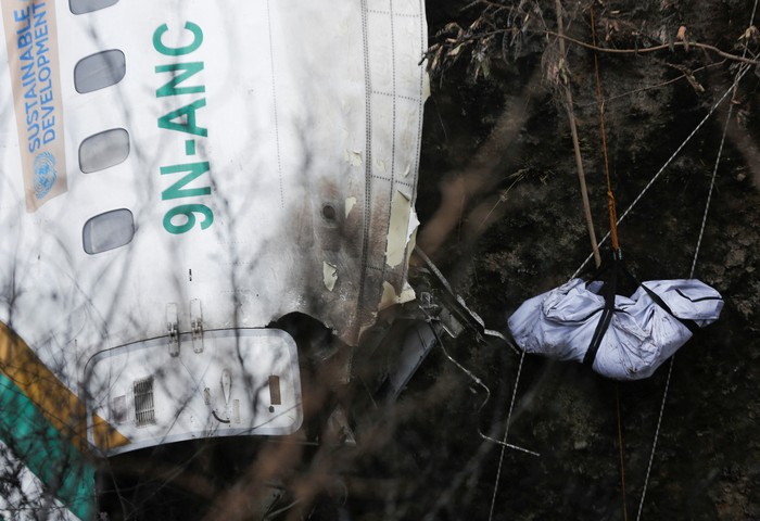 A rescue team recovers the body of a victim from the site of the plane crash of a Yeti Airlines operated aircraft, in Pokhara, Nepal January 16, 2023. REUTERS/Rohit Giri NO RESALES. NO ARCHIVES