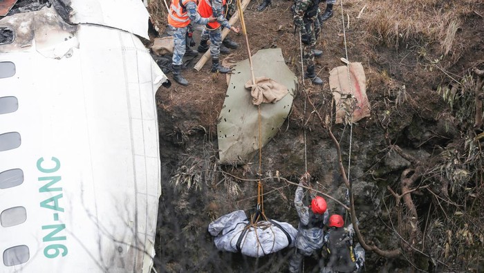 A rescue team recovers the body of a victim from the site of the plane crash of a Yeti Airlines operated aircraft, in Pokhara, Nepal January 16, 2023. REUTERS/Rohit Giri NO RESALES. NO ARCHIVES