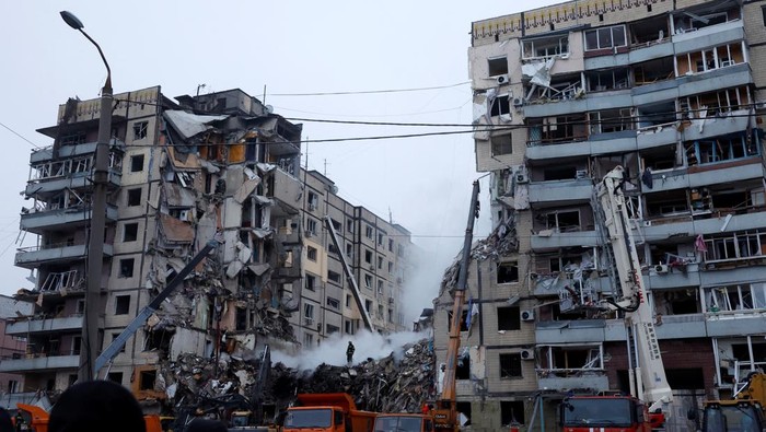 Emergency personnel move a dead body in a body bag after retrieving it at the site where an apartment block was heavily damaged by a Russian missile strike, amid Russia's attack on Ukraine, in Dnipro, Ukraine January 15, 2023. REUTERS/Clodagh Kilcoyne
