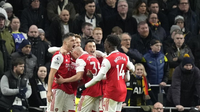 Arsenal players celebrate after Arsenals Martin Odegaard scored his sides second goal during the English Premier League soccer match between Tottenham Hotspur and Arsenal at the Tottenham Hotspur Stadium in London, England, Sunday, Jan. 15, 2023. (AP Photo/Frank Augstein)