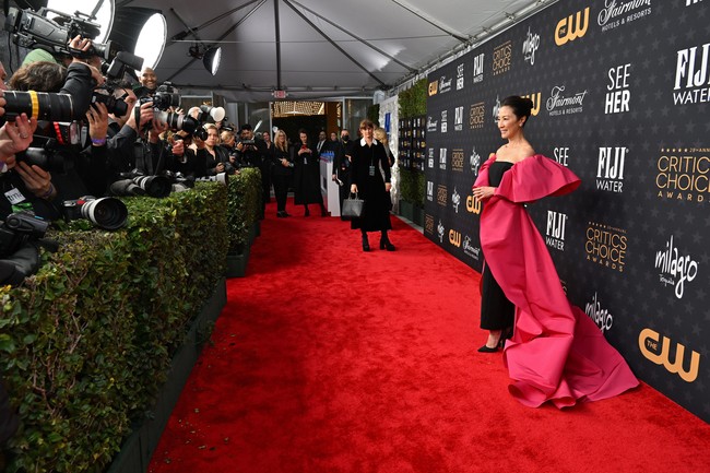 Sorotan juga tertuju pada Michelle Yeoh. Menyusul kemenangan bersejarahnya di Golden Globe Awards 2023 pekan lalu, aktris asal Malaysia ini menghadirkan drama di karpet merah Critics Choice dengan strapless column dress hitam yang dibungkus semacam luaran pink bervolume. Adalah Carolina Herrera, label yang mengeluarkan gaun ini.  (Foto: Michael Kovac/Getty Images for Champagne Collet & OBC Wines)