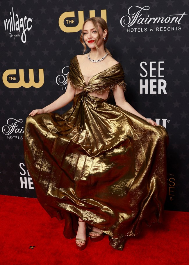 Aktris Amanda Seyfried bersolek bak golden girl dengan gaun emas Dior. Kepada Access Hollywood di karpet merah, Amanda mengaku sempat waswas memakai gaun dari koleksi lama Spring-Summer 2020 tersebut karena materialnya yang ringkih, yakni chiffon gold lame yang dilipat-lipat. Kendati demikian, penampilannya tetap memukau. (MICHAEL TRAN/AFP via Getty Images)