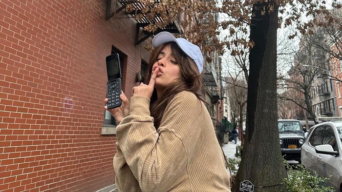 Penyanyi Camila Cabello bersama HP lipat TCL miliknya