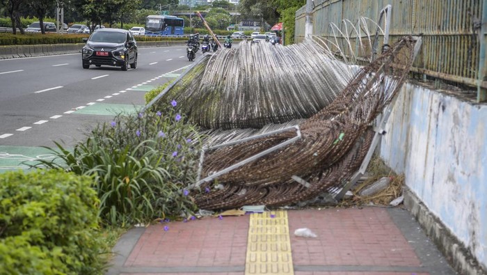 Duh.. Akses Buat Pejalan Kaki Jadi Terhalang Gegara Ada Kawat Berduri Pengendara kendaraan bermotor melintas di samping trotoar yang terhalang kawat berduri di Jalan Gatot Subroto, Jakarta, Senin (16/1/2023). Keberadaan kawat berduri tersebut mengganggu akses pejalan kaki serta menutup jalur pemandu khusus penyandang disabilitas (guiding block). ANTARA FOTO/Galih Pradipta/rwa.